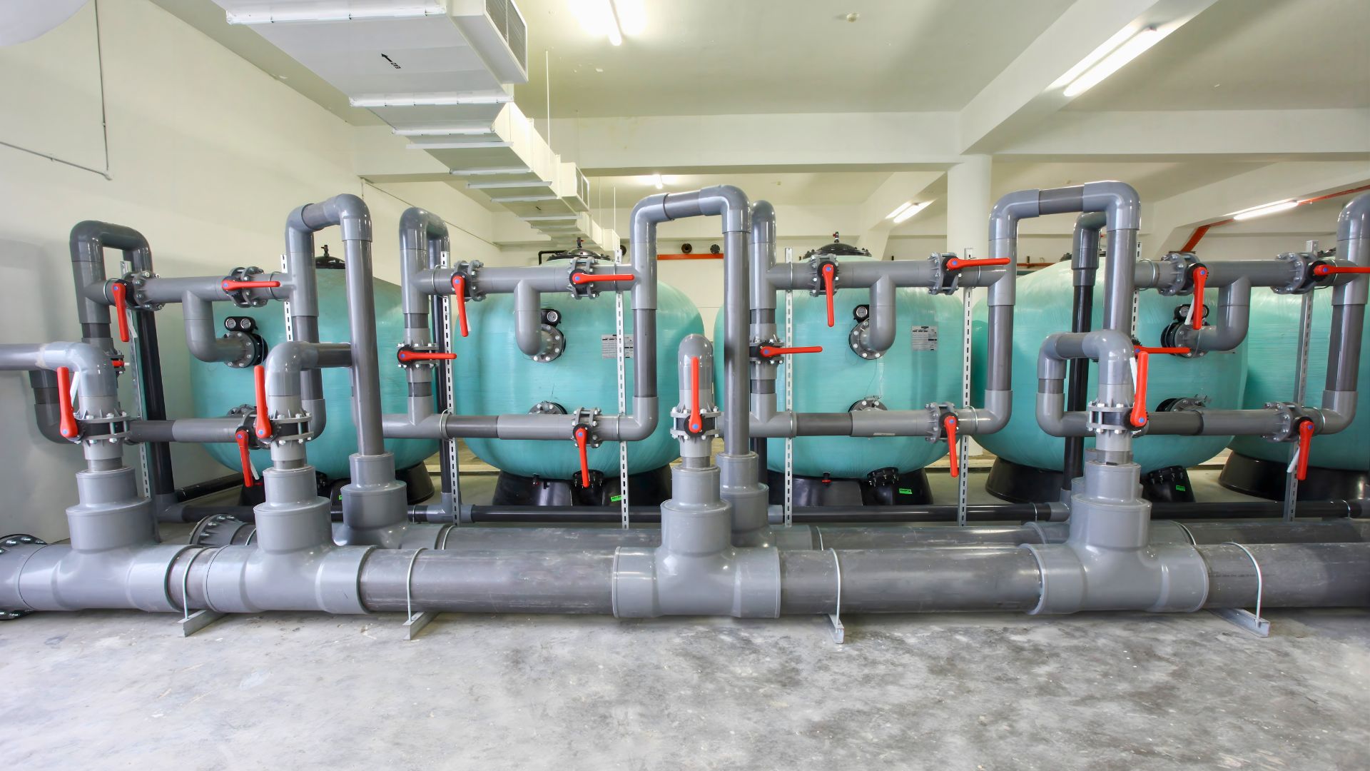 Horizontal view of the pool filters and the UPVC piping system connecting them, at the Anglo-Chinese School Independent pump room. Valves have been inserted in between the equipment, and have been adjusted to various positions.