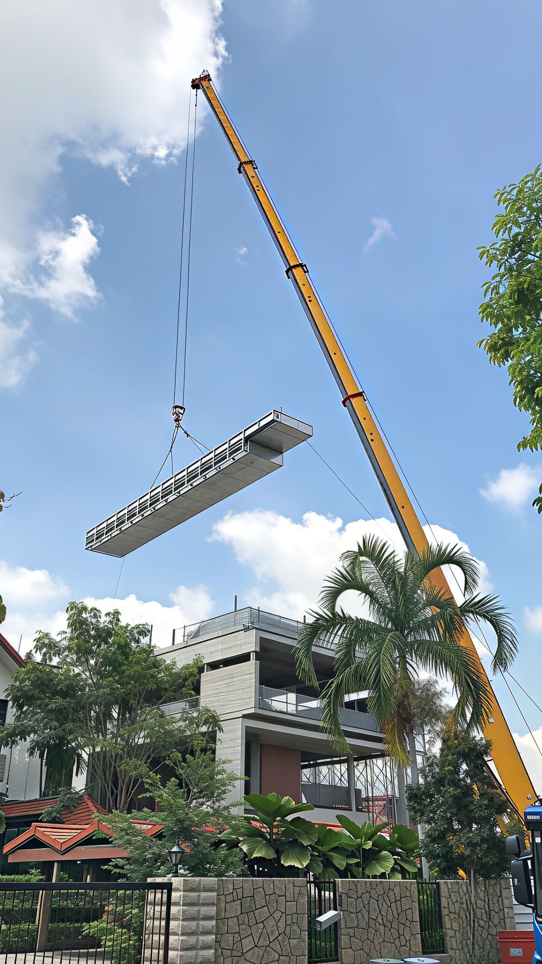 A construction robot hoists sheets of stainless steel pieces up onto the rooftop of a private landed home in Singapore, meant for swimming pool construction.