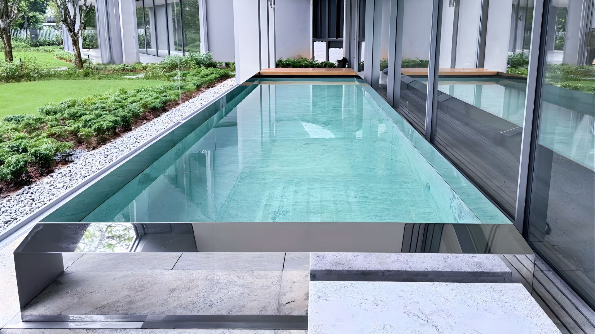 The stainless steel mirror pool at Les Maisons Nassim, Singapore, precisely engineered for a sleek and streamlined finish. Paired with fine viscount white granite and surrounded by lush greenery, the lap pool looks like the epitome of luxury.