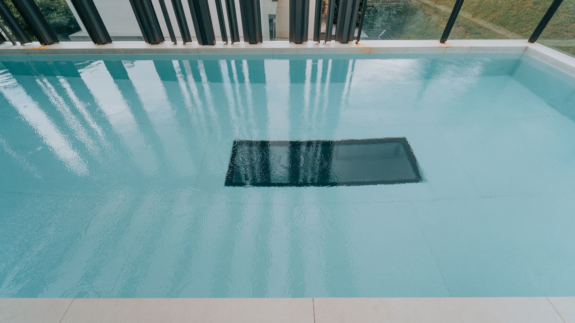 Close-up of the underwater window within the swimming pool of a private residence in Singapore, which allows swimmers to look down into the living areas of the house below.