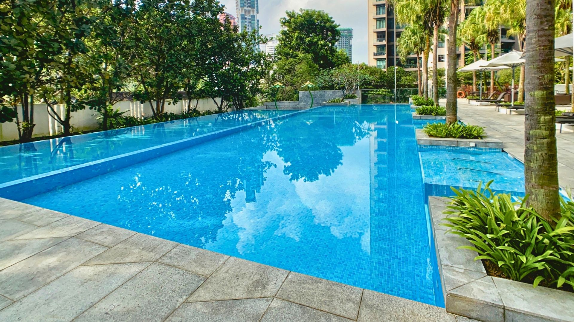 Eye-level view of the main 50-metre swimming pool at Paterson Suites in Singapore. Jaccuzi lounges are incorporated at the side perimeter of the swimming pool.