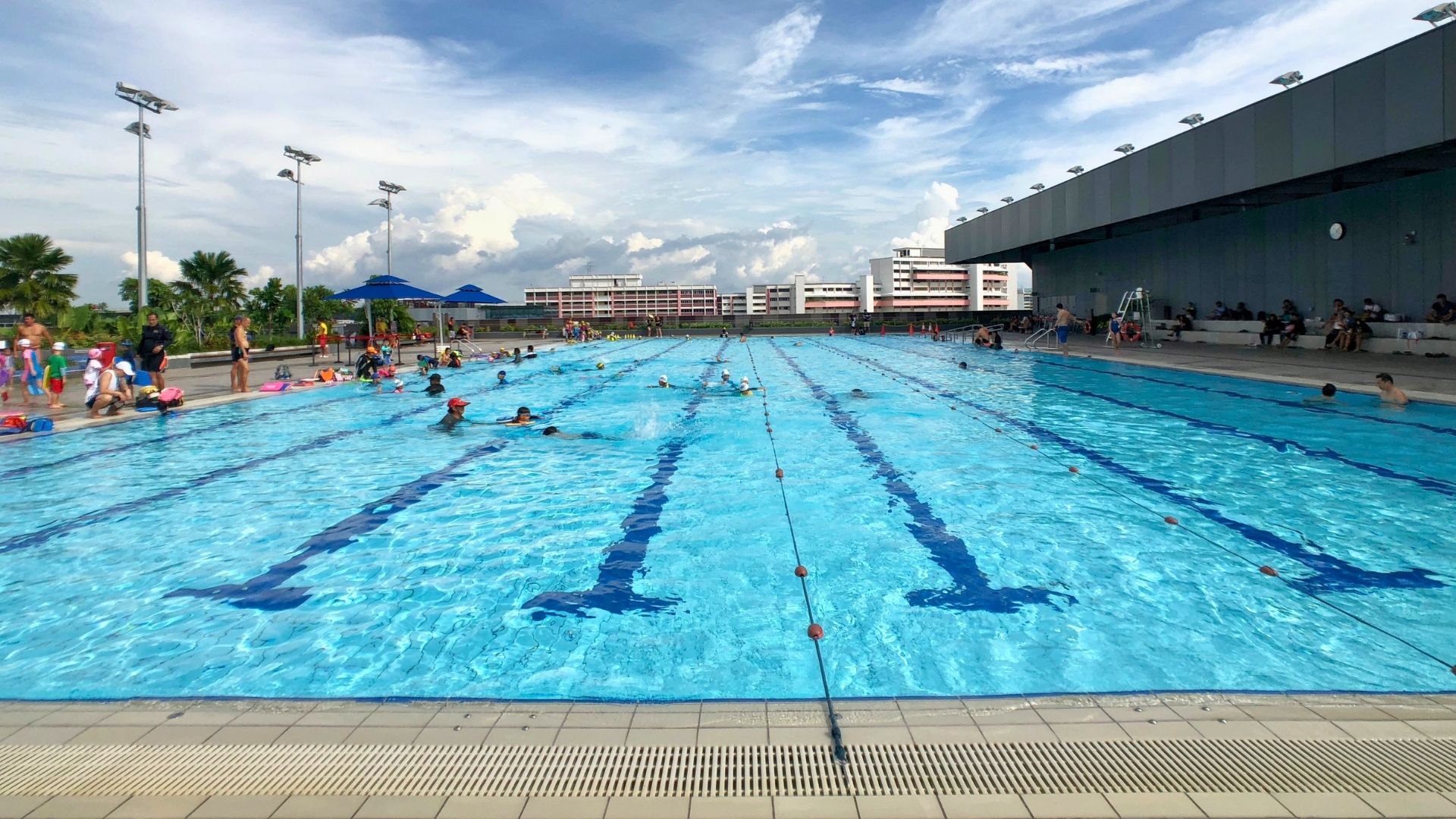 The lanes of the outdoor training pool at Our Tampines Hub are divided with thin ropes. Swimmers swim laps on one side, whilst swimming lessons take place on the other.