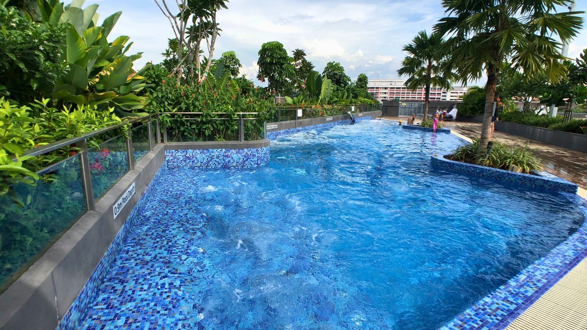 The spacious outdoors spa tub at Our Tampines Hub in Singapore. The edges are curved, and the surface of the water bubbles from the pressure of the jets.
