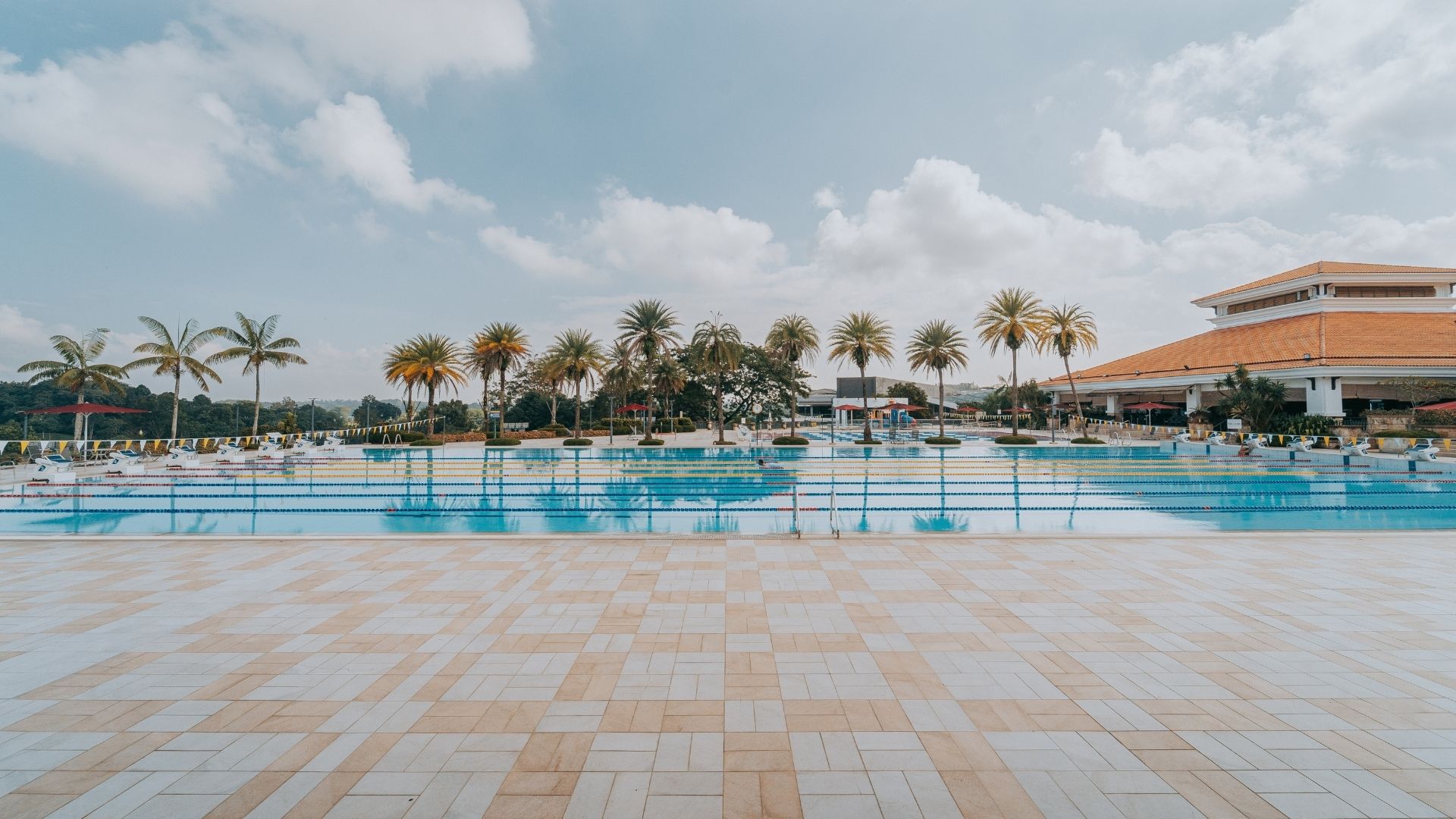 View of the 50-metre competition pool at the Singapore Island Country Club, along its length. The pool appears well-equipped with pool accessories such as flags and ropes.