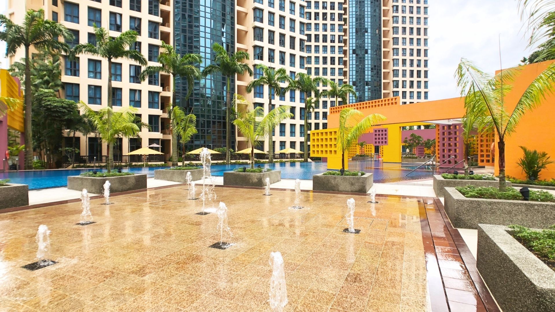 Close-up of the water fountain features at Tanglin View Condominium in Singapore. A large swimming pool with a well-structured pool deck is behind is.