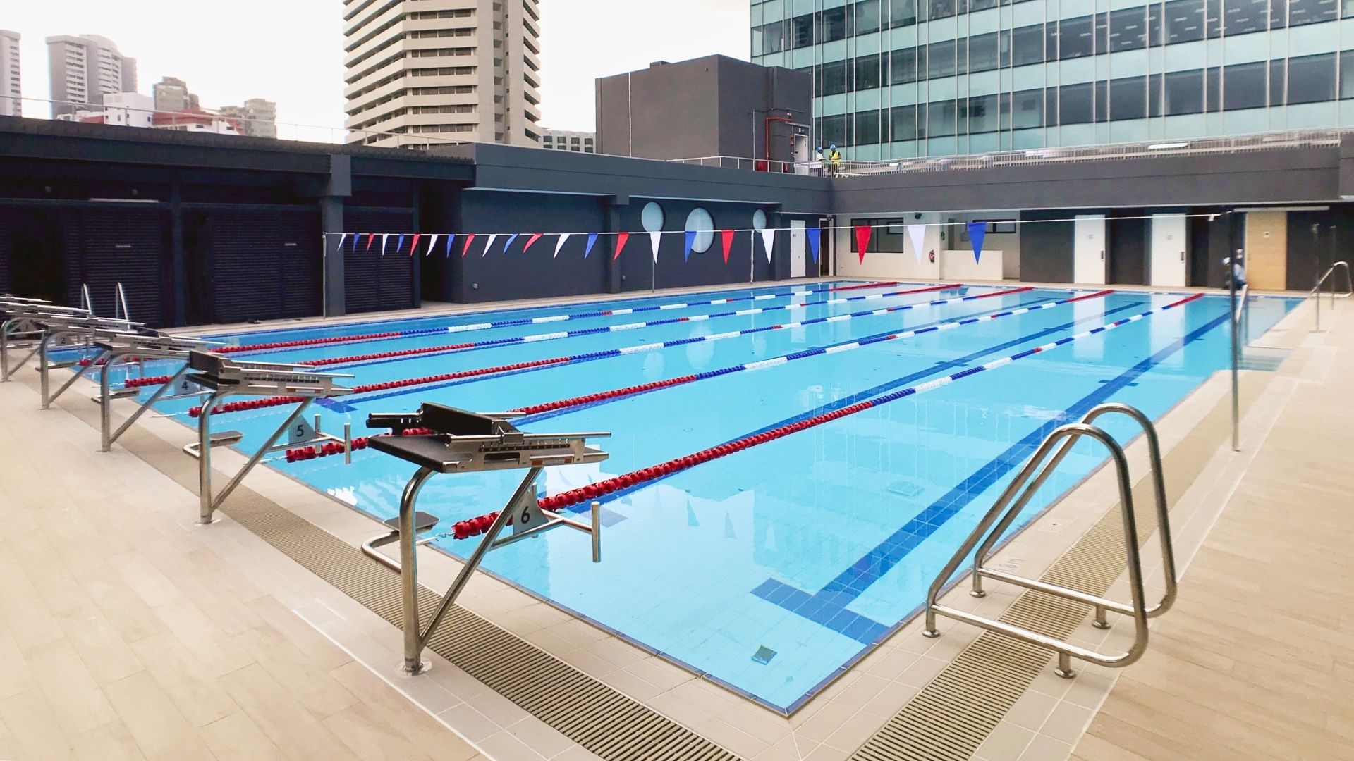 The upgraded 25-metre long training pool at The American Club Singapore. The starting blocks, grab rails, and backstroke poles are made of stainless steel. Other pool accessories such as flags and lane ropes furnish the pool.