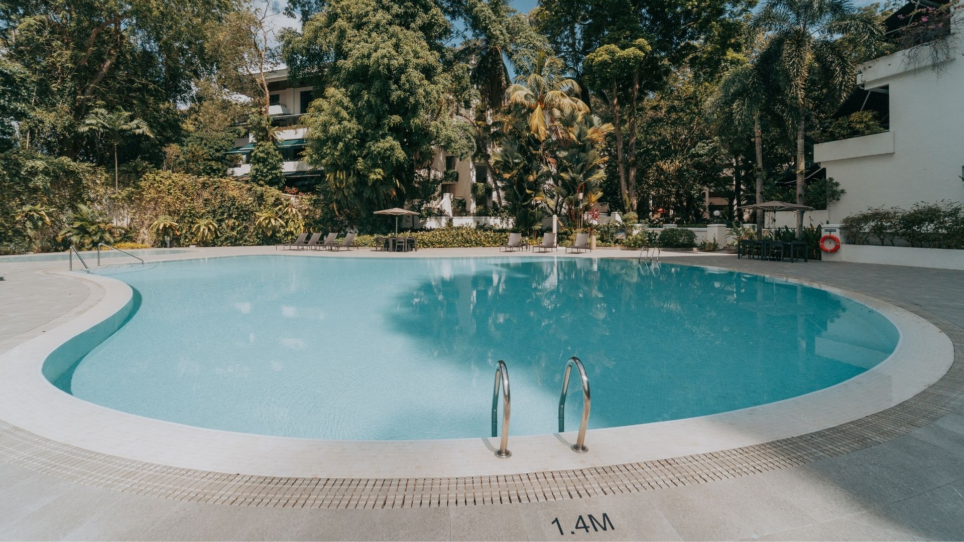 The newly-renovated stainless steel swimming pool at The Arcadia Condominium in Singapore. A pool ladder leads into the pool at the deep end, with the pool depth, 1.4 metres, printed on the Spanish porcelain-tiled deck behind it.