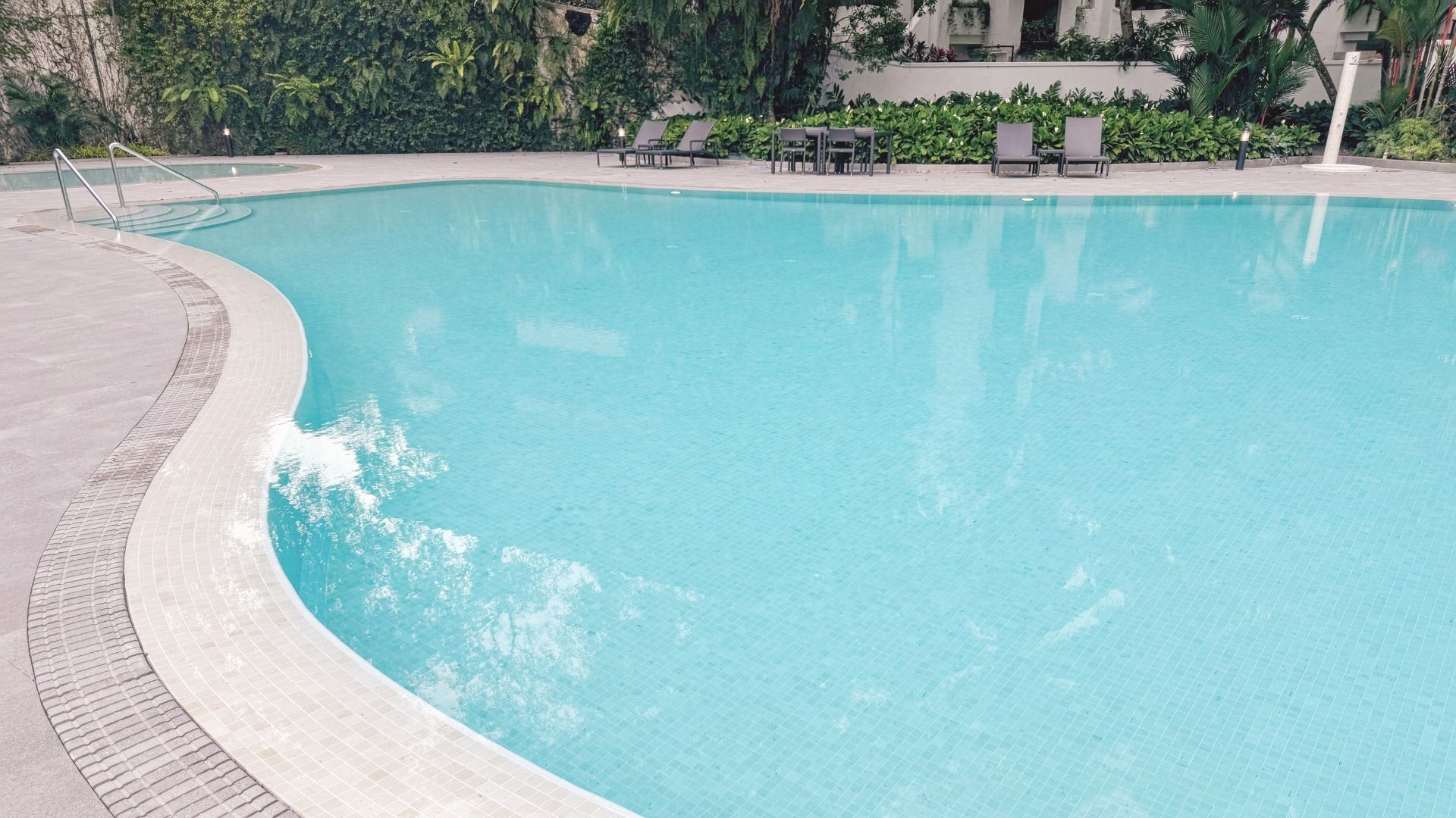The curvaceous edge of the swimming pool at The Arcadia. The tile finishings of the pool are made up of Spanish glass mosaic, whilst the pool deck comprises Spanish porcelain tiles with matching tile gratings. They make the pool area look elegant.
