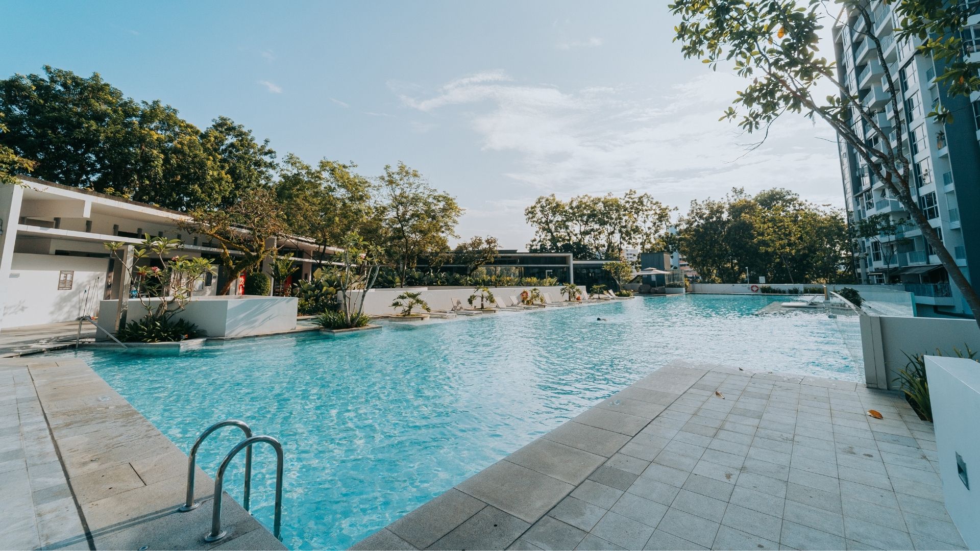 The upgraded 50-metre swimming pool at The Estuary Condominium in Yishun, Singapore. The concrete deck tiles have undergone re-tiling, and a stainless steel pool ladder leads into the pool at the deep end.
