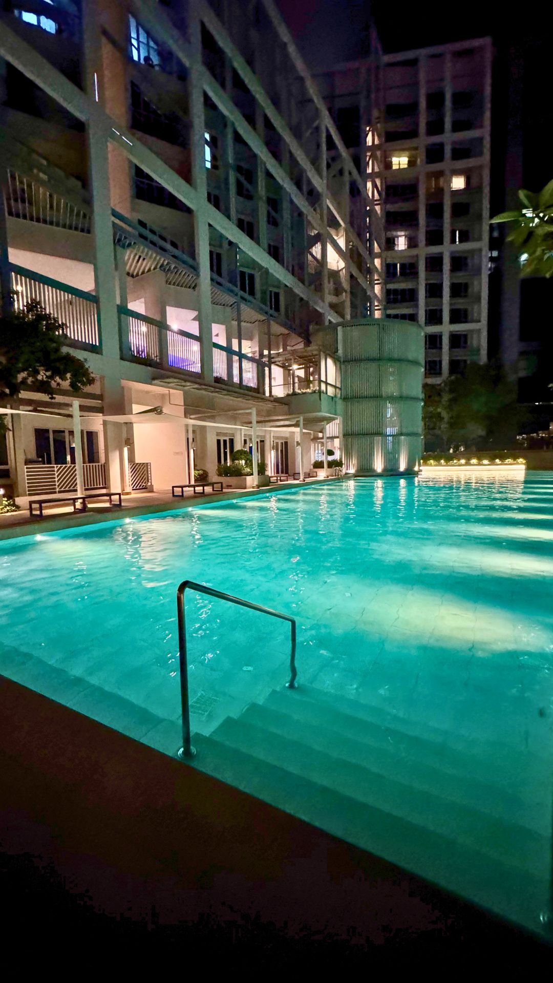 The Visioncrest Residence swimming pool is well-lit at night with underwater lights, and light from the pool deck and surroundings. The pool steps have been partitioned into sections with different heights, with grab rails for better accessibility.