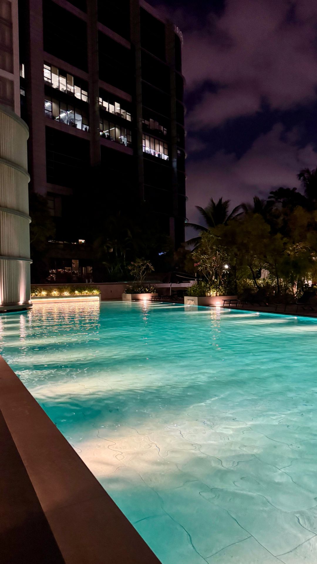 Diagonal view of the upgraded Visioncrest Residence swimming pool, well lit up at night.