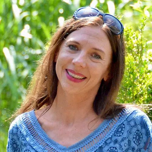 Daniela aus Ottobrunn, lächelt zufrieden über ihren neu angelegten Garten von Dein Glücksgarten