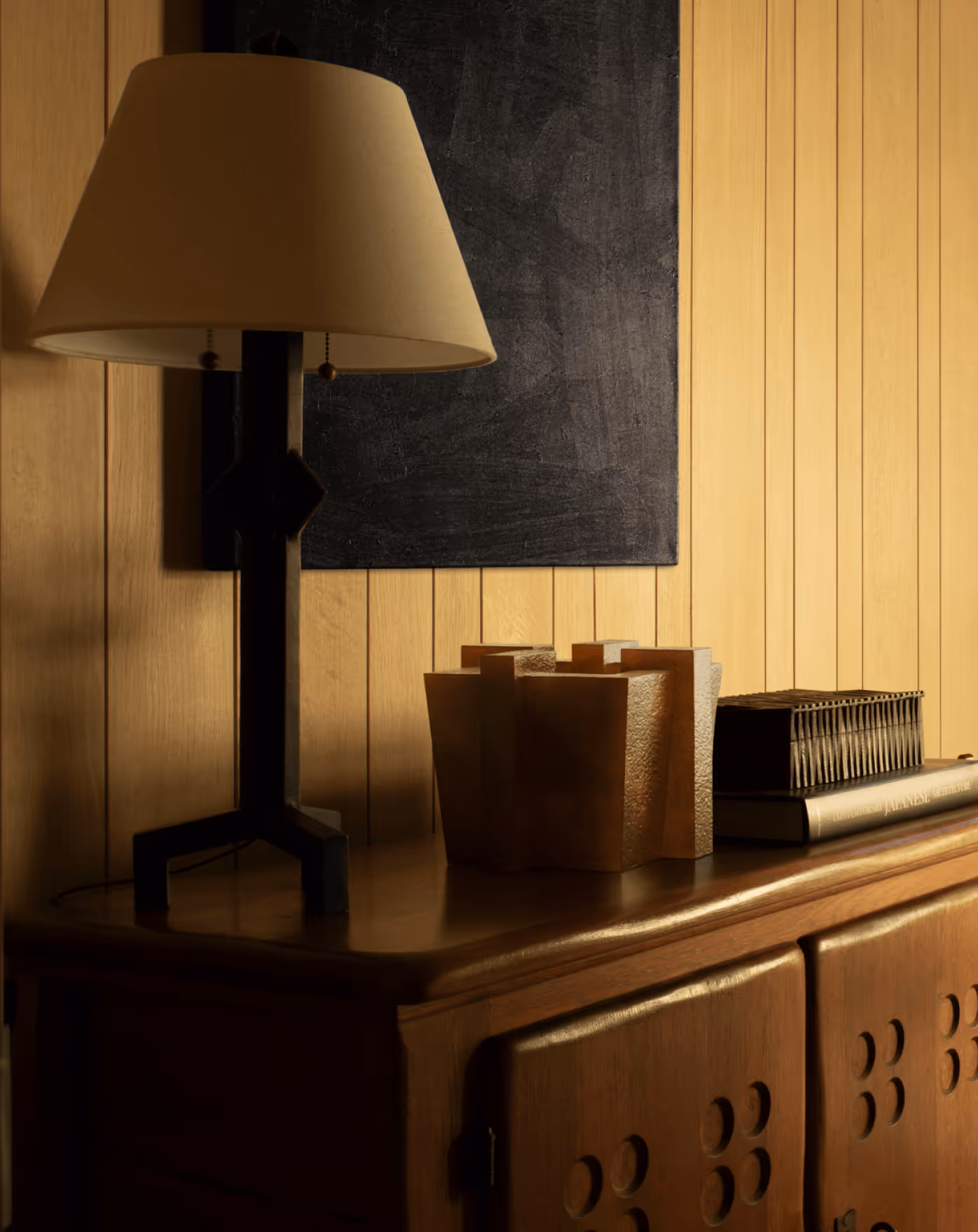 Monolith vase in ochre standing on a wooden sideboard