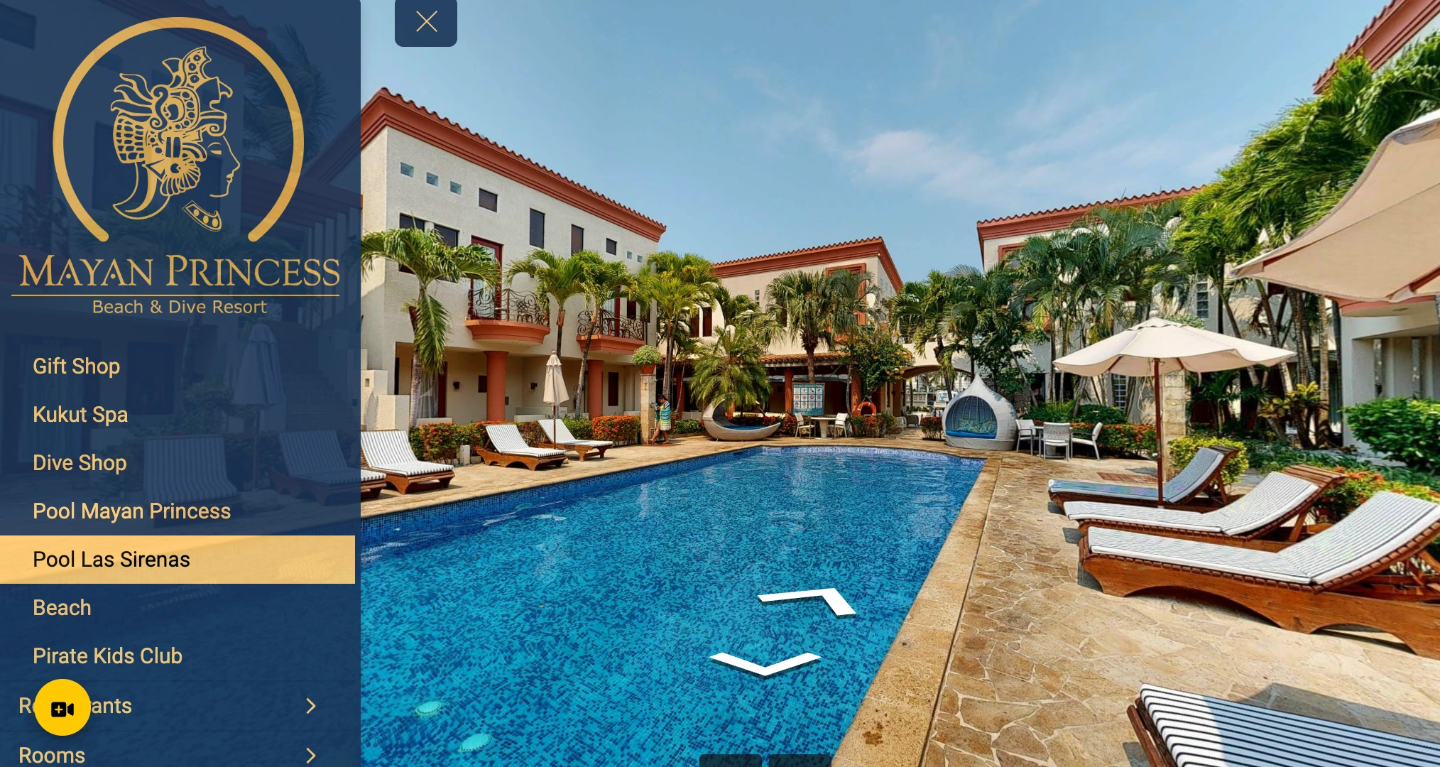 Outdoor swimming pool surrounded by lounge chairs, umbrellas, and tropical palm trees at Mayan Princess Beach & Dive Resort.