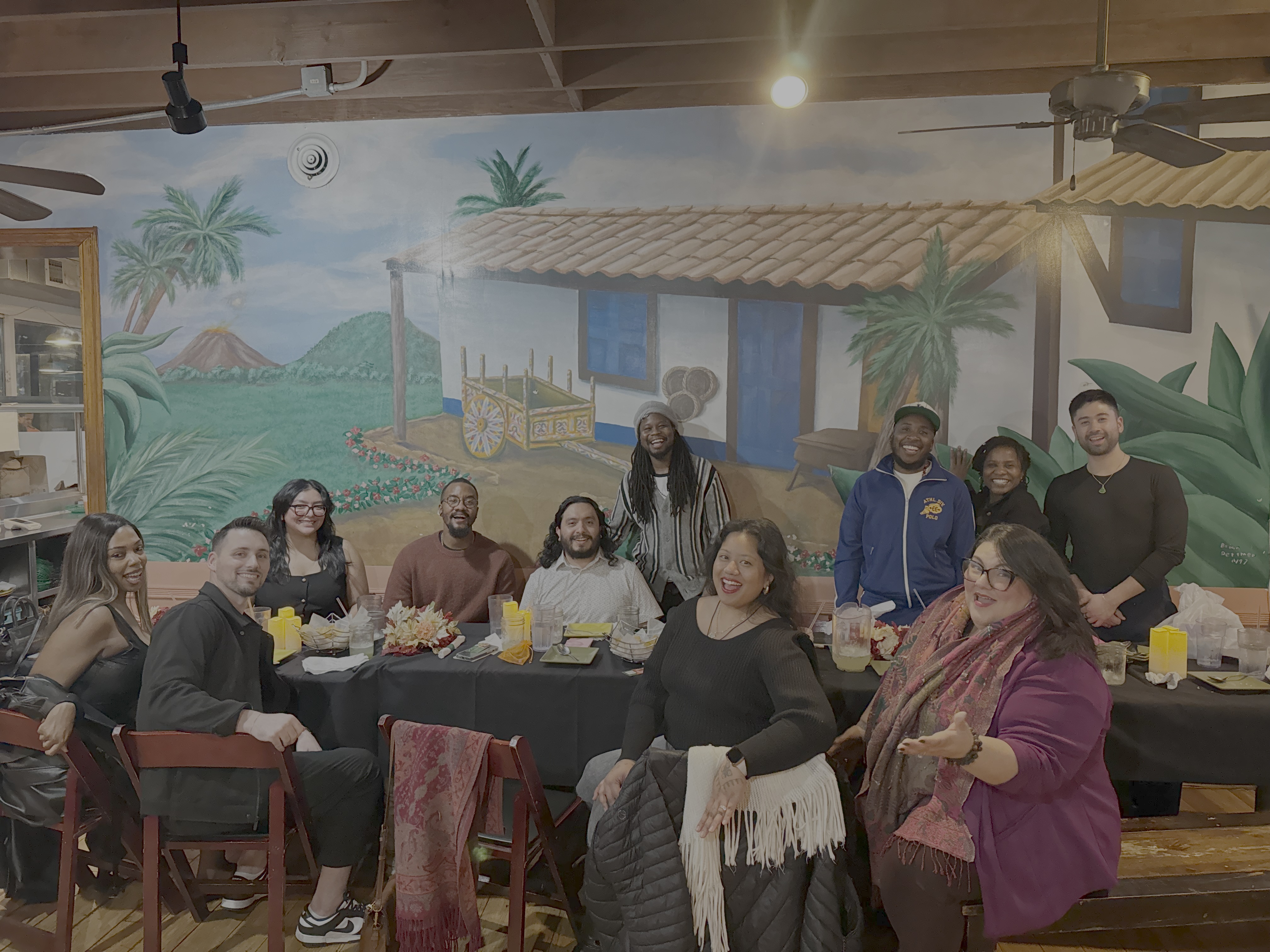 People gathered around table smiling having dinner