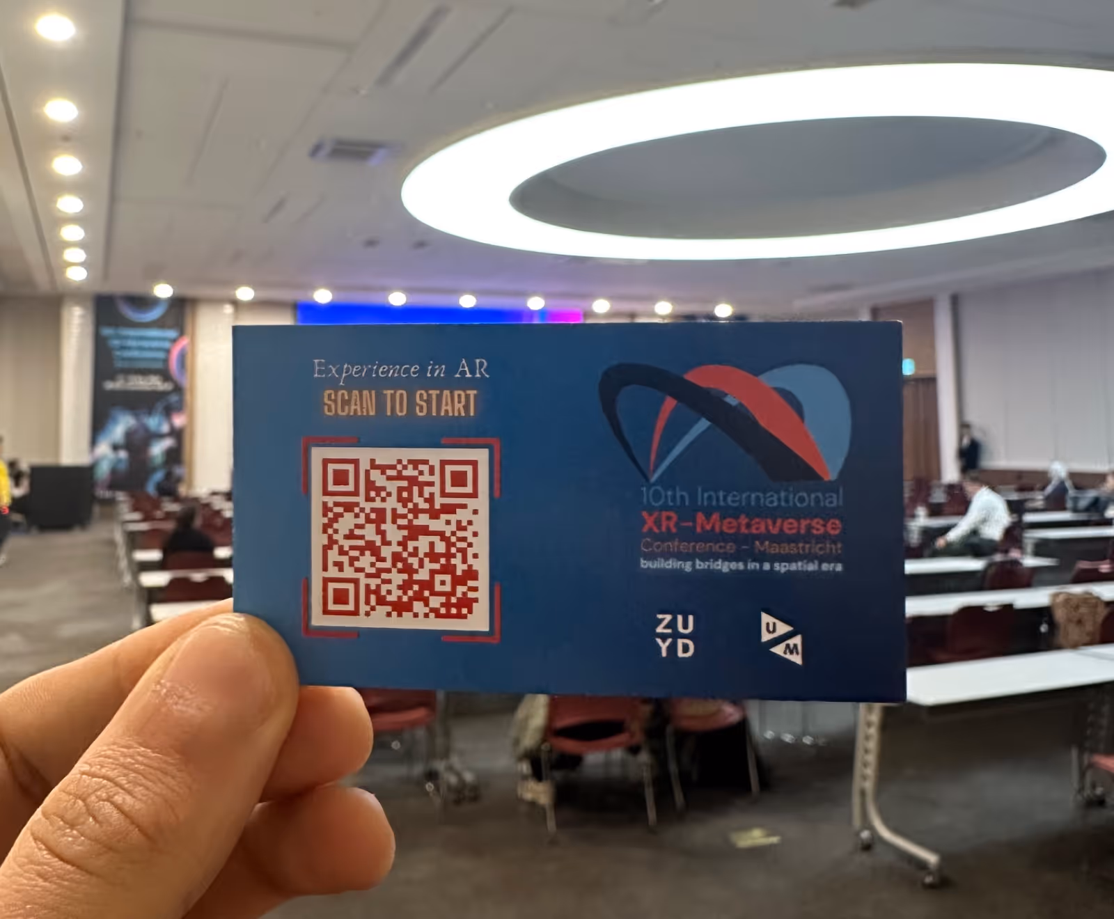 Cartoon character with a blue top hat and vest standing on a small platform with palm trees in a blurred indoor room.