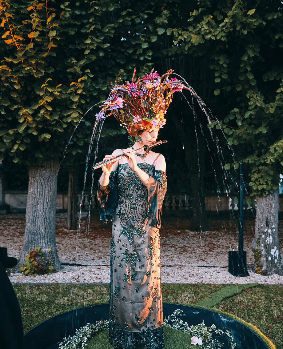 Sunlight shining through hanging white flowers and green leaves in an outdoor setting.
