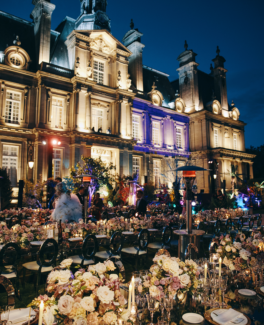 Sunlight shining through hanging white flowers and green leaves in an outdoor setting.
