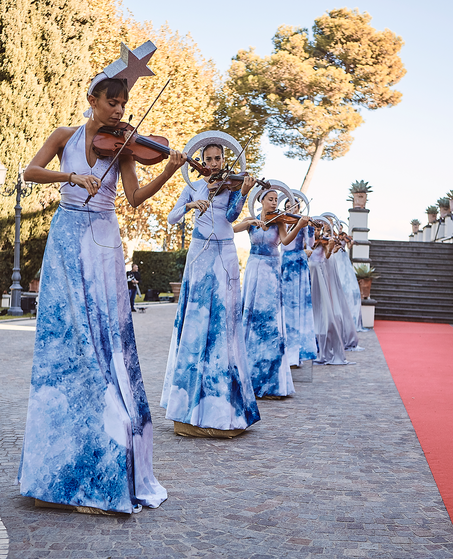 Sunlight shining through hanging white flowers and green leaves in an outdoor setting.