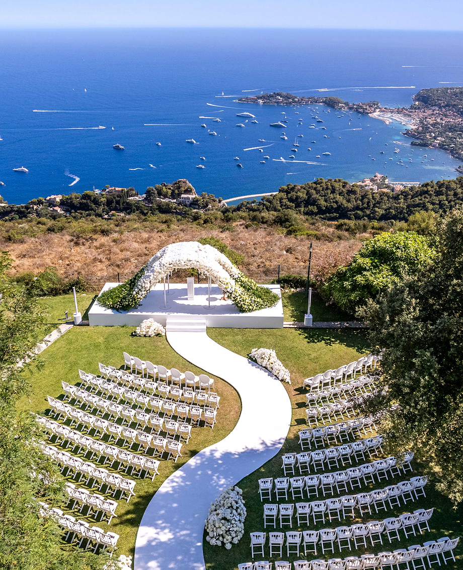 Sunlight shining through hanging white flowers and green leaves in an outdoor setting.