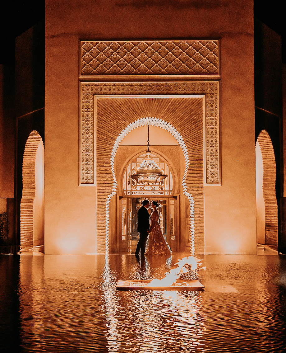 Sunlight shining through hanging white flowers and green leaves in an outdoor setting.