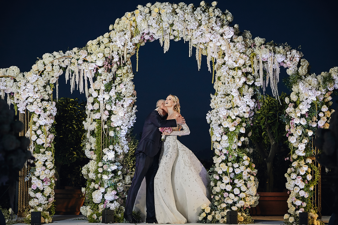 Sunlight shining through hanging white flowers and green foliage decorations.