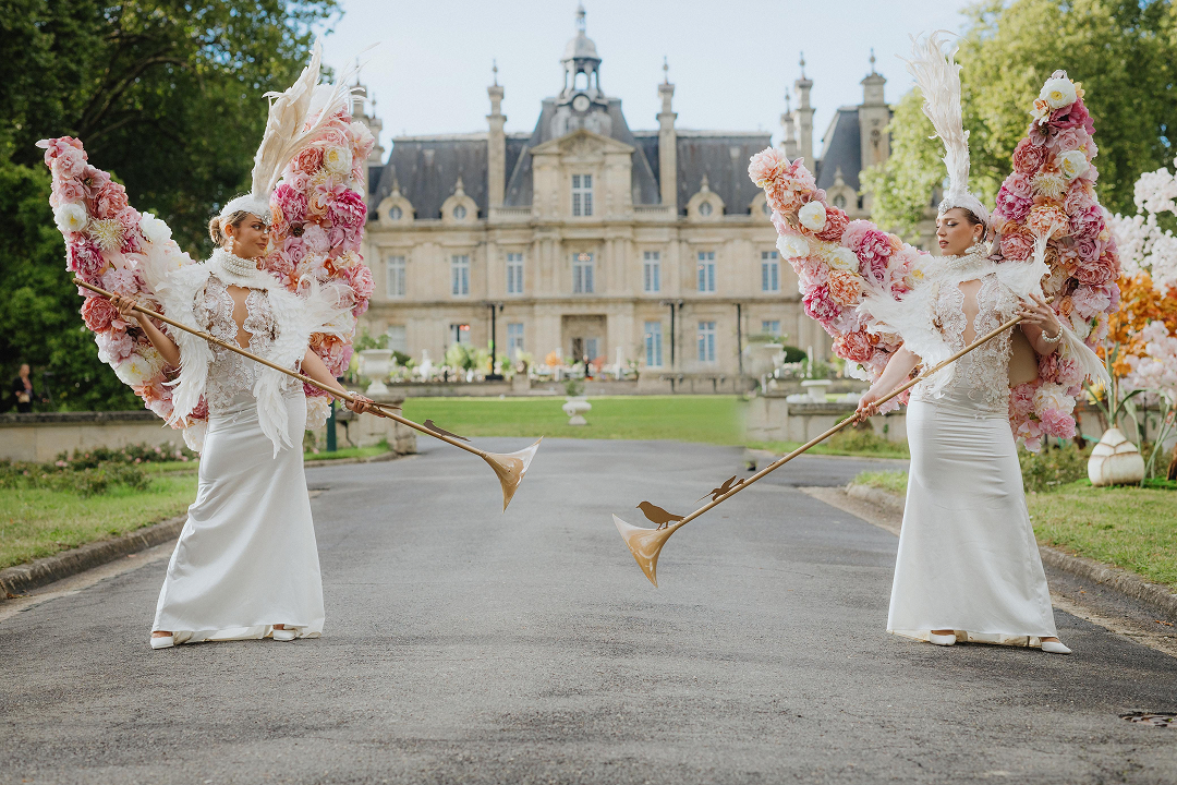 Sunlight shining through hanging white flowers and green foliage decorations.