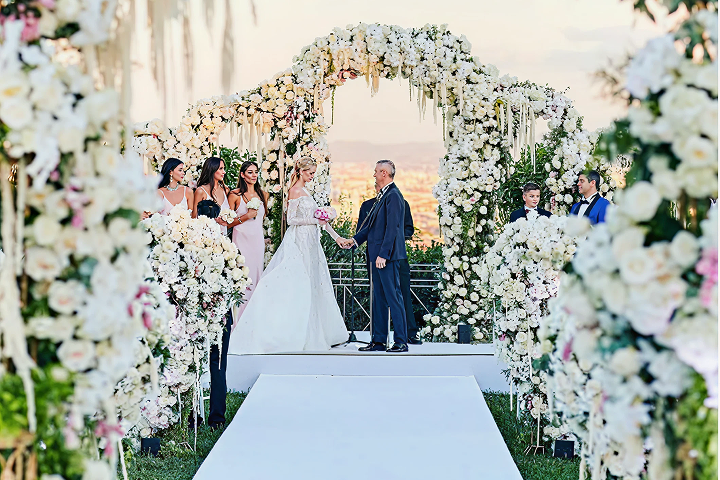 Sunlight shining through hanging white flowers and green foliage decorations.