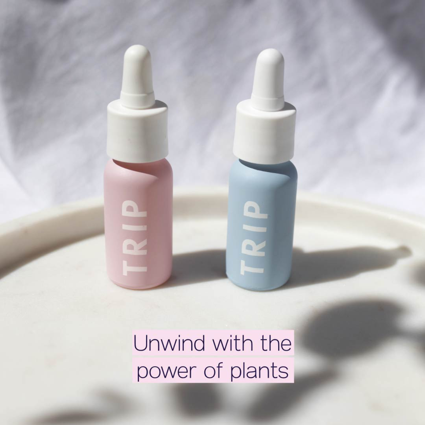 Product photography of TRIP wellness bottles in soft natural lighting