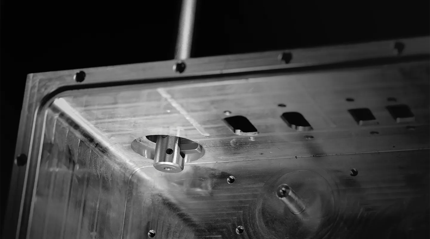 Close-up van een precisie gefreesd metalen machineonderdeel in zwart-wit.