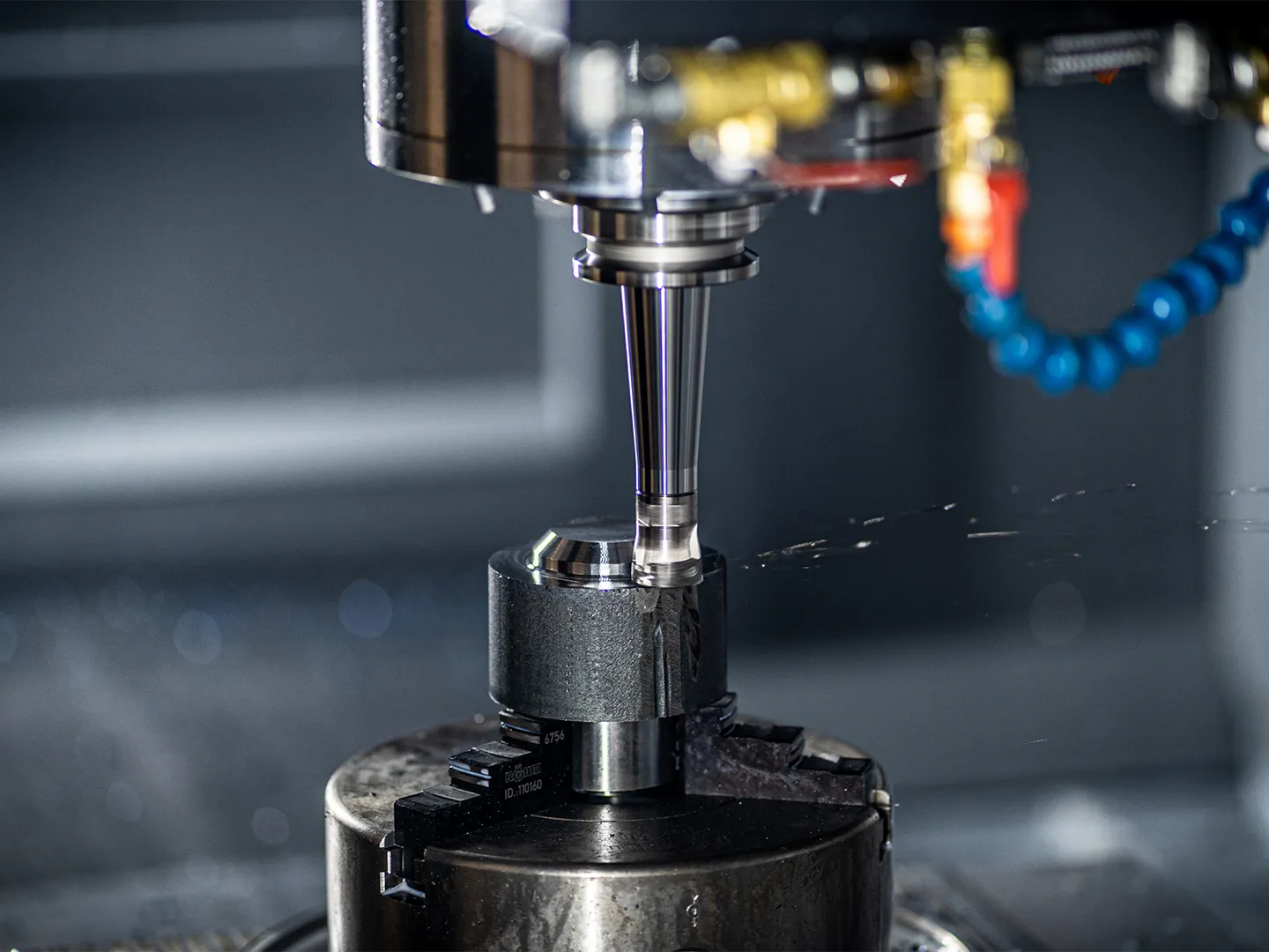 CNC-frees bewerkt een metalen werkstuk met hoge precisie in industriële omgeving.