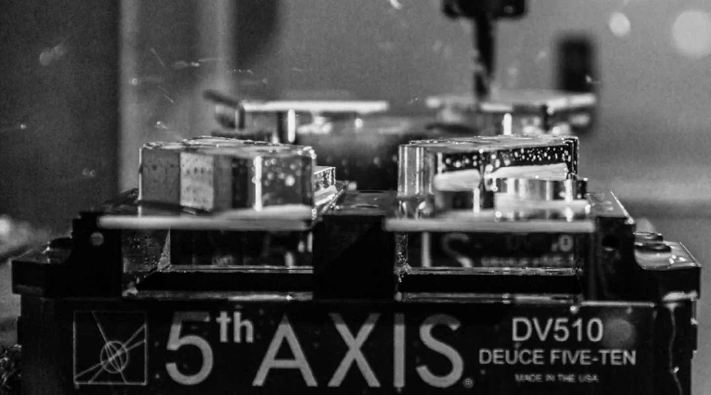 Close-up van een precisie gefreesd metalen machineonderdeel in zwart-wit.