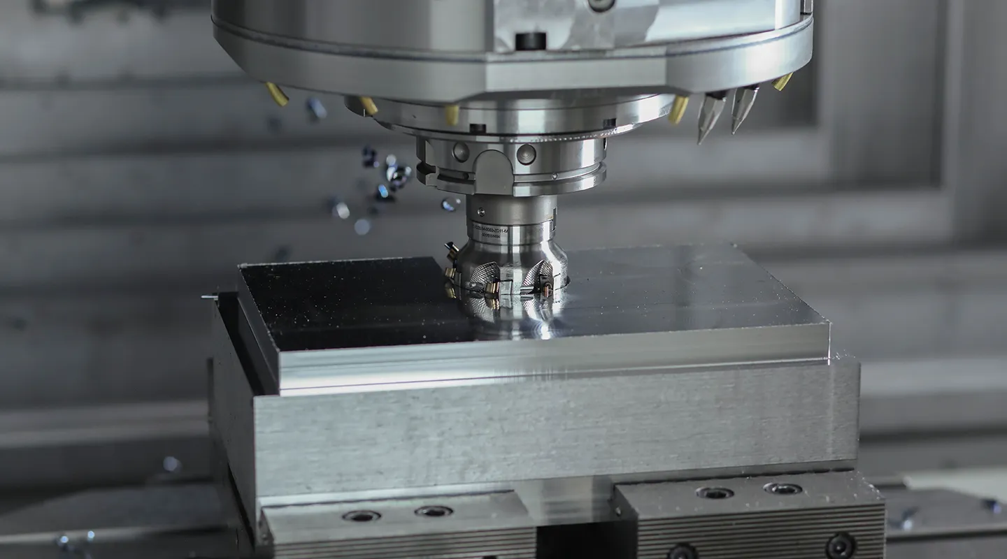 Close-up van een precisie gefreesd metalen machineonderdeel in zwart-wit.