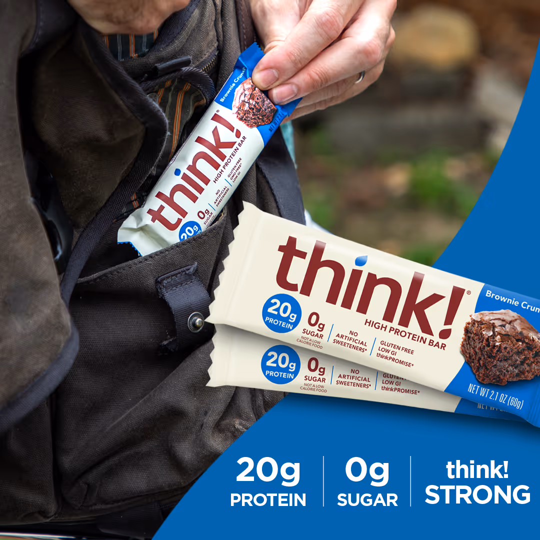 Hand placing a think! high protein brownie crunch bar into a backpack pocket, with text highlighting 20g protein, 0g sugar, and think! STRONG.