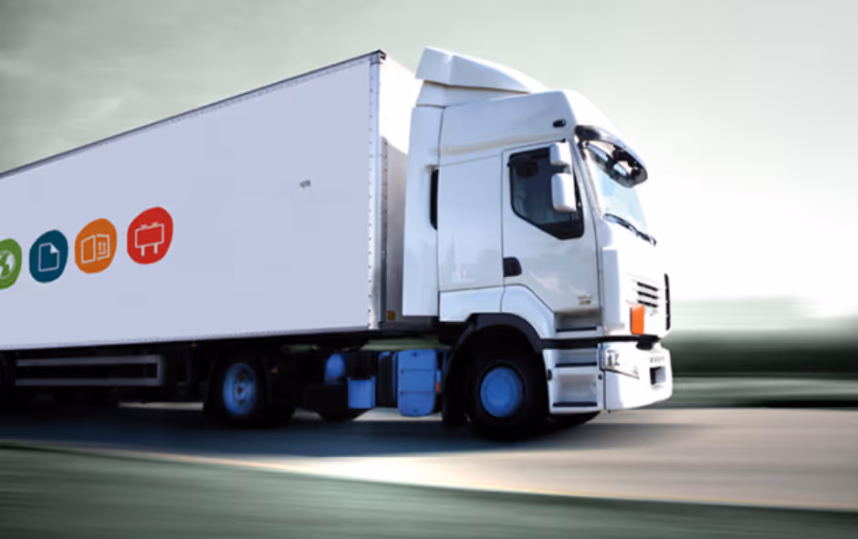 Camião branco a circular numa estrada, com ícones coloridos na lateral da carrinha.