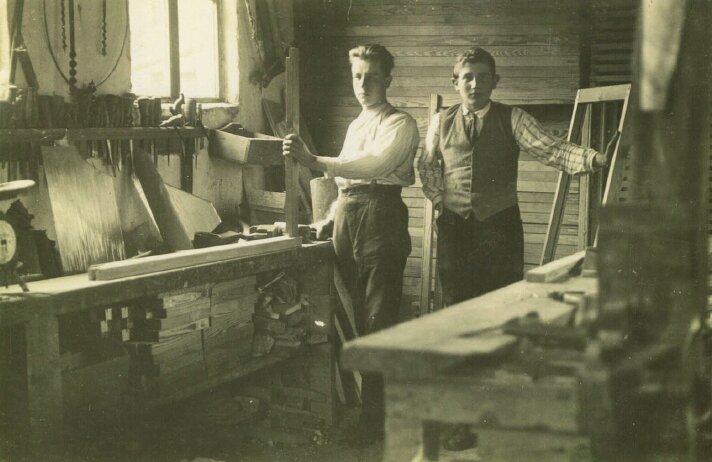 Historische foto circa 1930: twee mannen aan het werk in een timmerwerkplaats, begin van de bedrijfsgeschiedenis van SMD Groep.