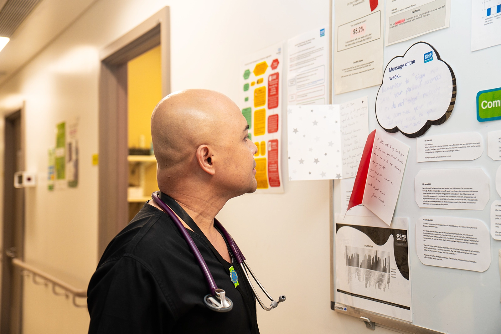 Healthcare professional with stethoscope looking at a notice board with papers and messages.