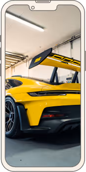 Vue arrière d'une voiture de sport jaune avec un grand aileron dans un garage.