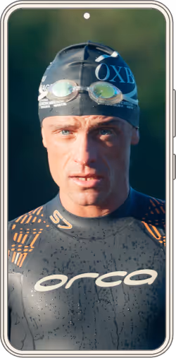 Homme portant un bonnet de bain noir avec lunettes de natation, en combinaison de triathlon Orca mouillée.