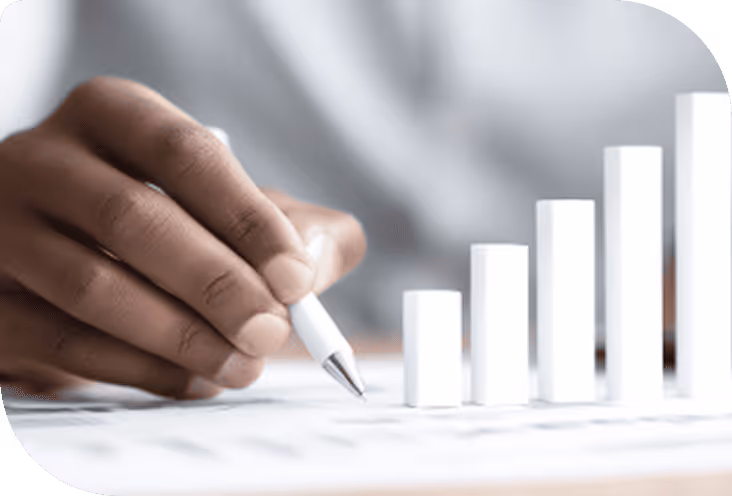 Main tenant un stylo blanc près d'un graphique à barres en croissance sur une feuille.