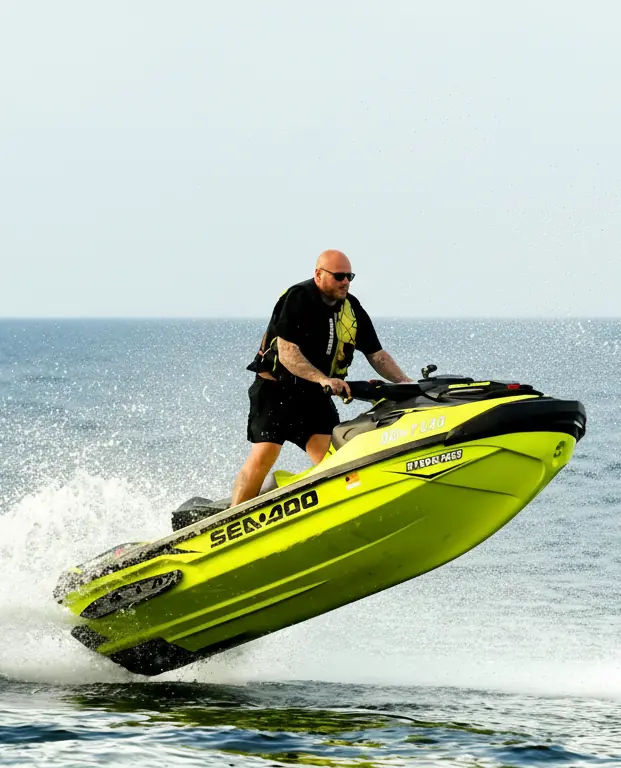 Hombre usando moto de agua verde en el mar
