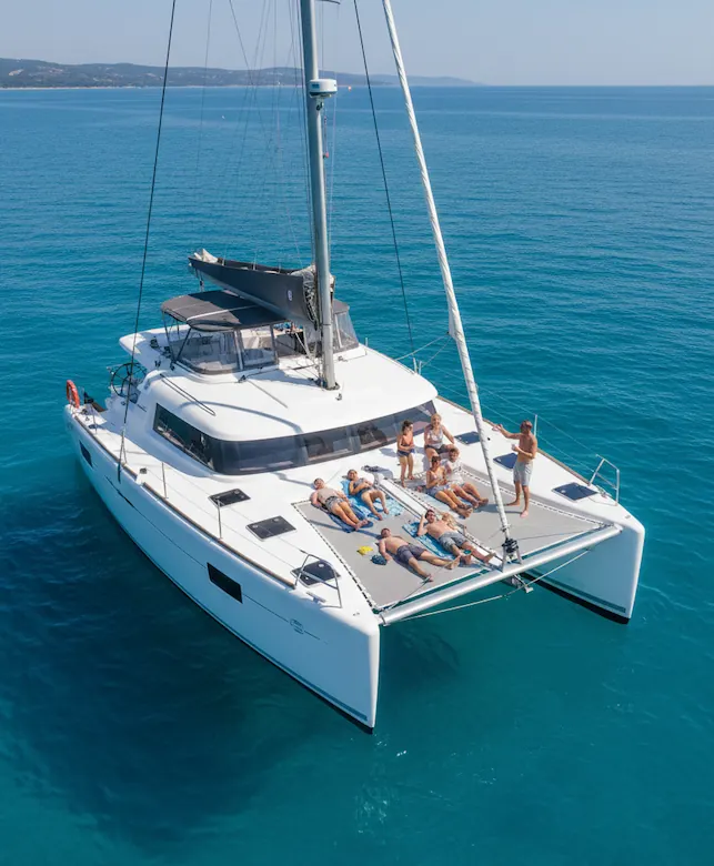 Catamarán en medio del mar con gente en la cubierta