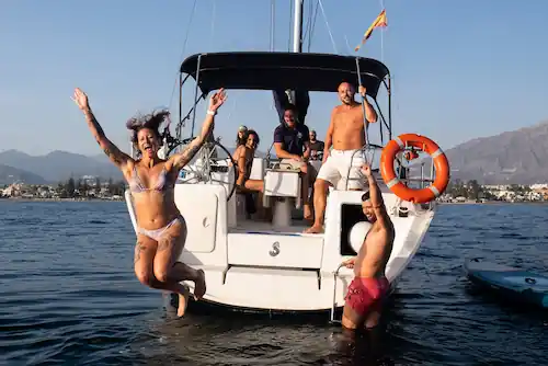 Gente saltando en la popa del Velero Beneteau Cyclades 39 Mistral