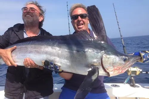 Hombres sosteniendo un pez en la Lancha Rodman 1250 Luna