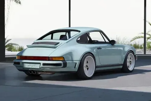 Singer’s latest reimagined 911 blends wide-body '80s looks with a 4.0L VVT flat-six, hybrid cooling, and F1-grade chassis tech from Red Bull. Rear three quarter view