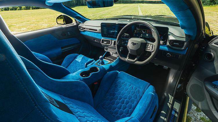 Interior view of the Clive Sutton CS800DH Mustang, featuring bright blue Alcantara Recaro seats, matching dashboard and door trim, a short-throw shifter, and digital instrument cluster with Mustang branding.