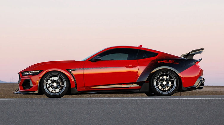 Side view of the Shelby Super Snake-R showing its widebody arches, carbon aero elements, five-spoke magnesium wheels and large rear wing against a desert backdrop.