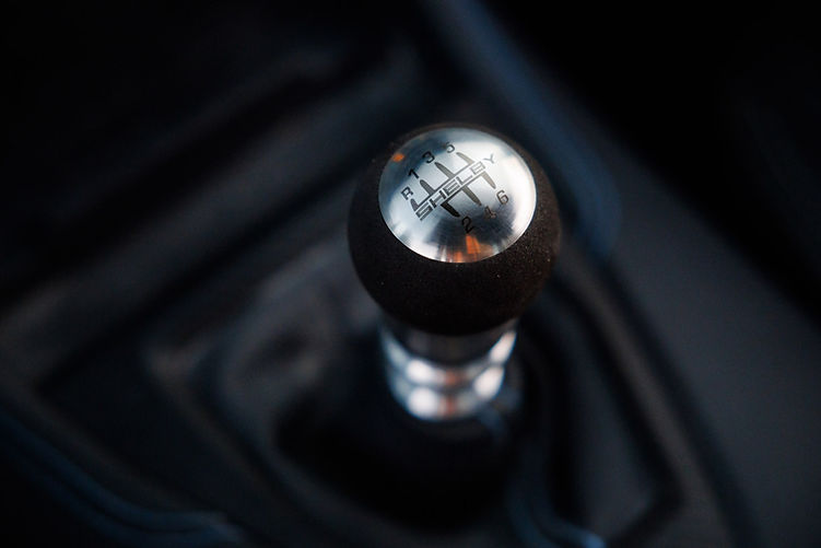 Close-up of the Shelby-branded gear shifter in the Super Snake-R, featuring a six-speed manual H-pattern layout with a metal and Alcantara finish.