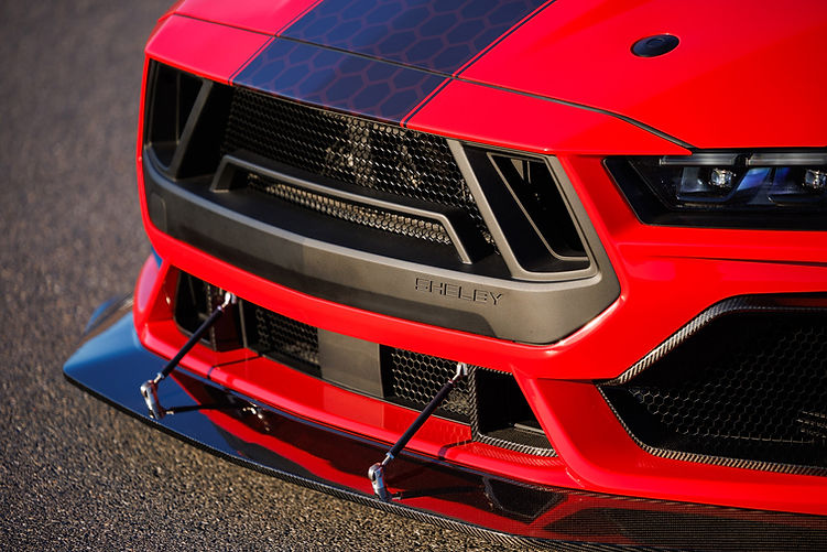 Close-up of the Shelby Super Snake-R’s carbon front splitter with support rods, aggressive grille design and Shelby-branded bumper trim.