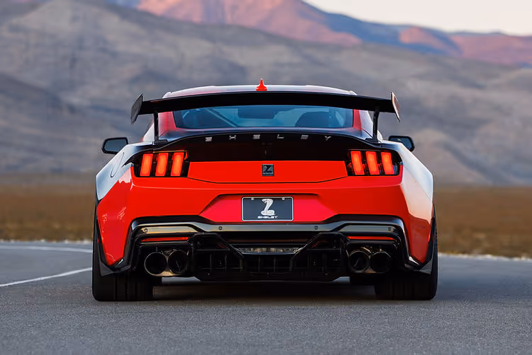 Rear view of the Shelby Super Snake-R showcasing quad exhaust tips, carbon rear diffuser, widebody arches and pedestal wing, with desert mountains in the background.